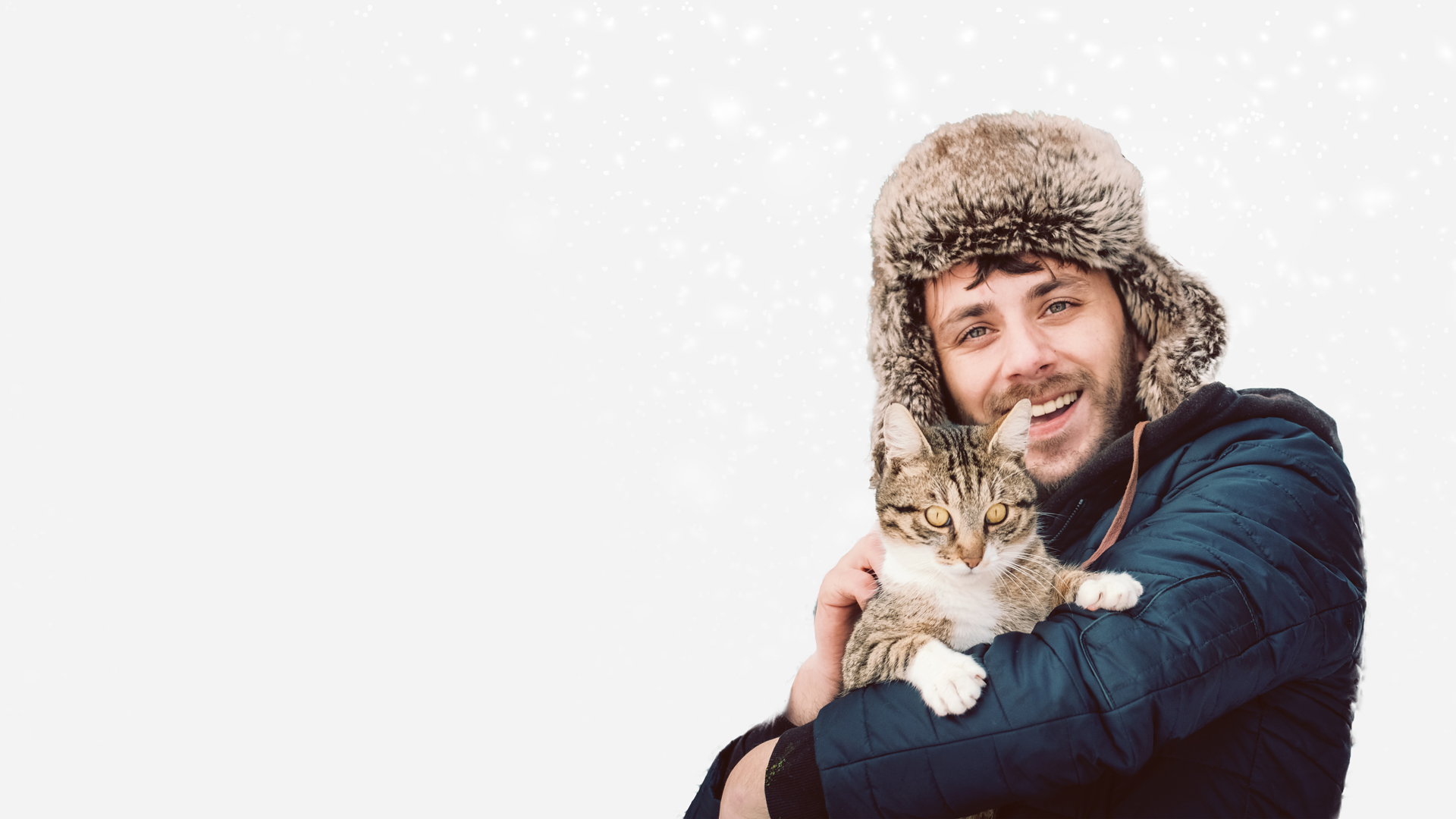 A man in a fuzzy hat holding a tabby cat