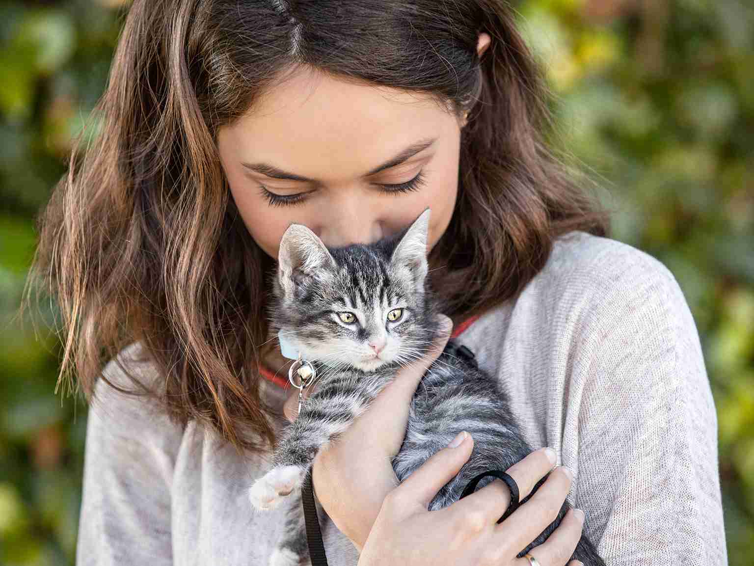 A young girl hugging a kitten
