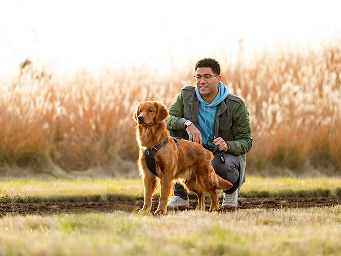 A man outside with his Golden Retriever