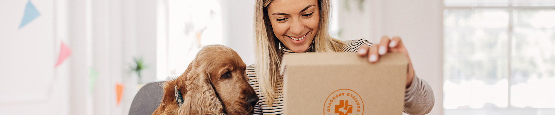 A woman and dog looking in a box