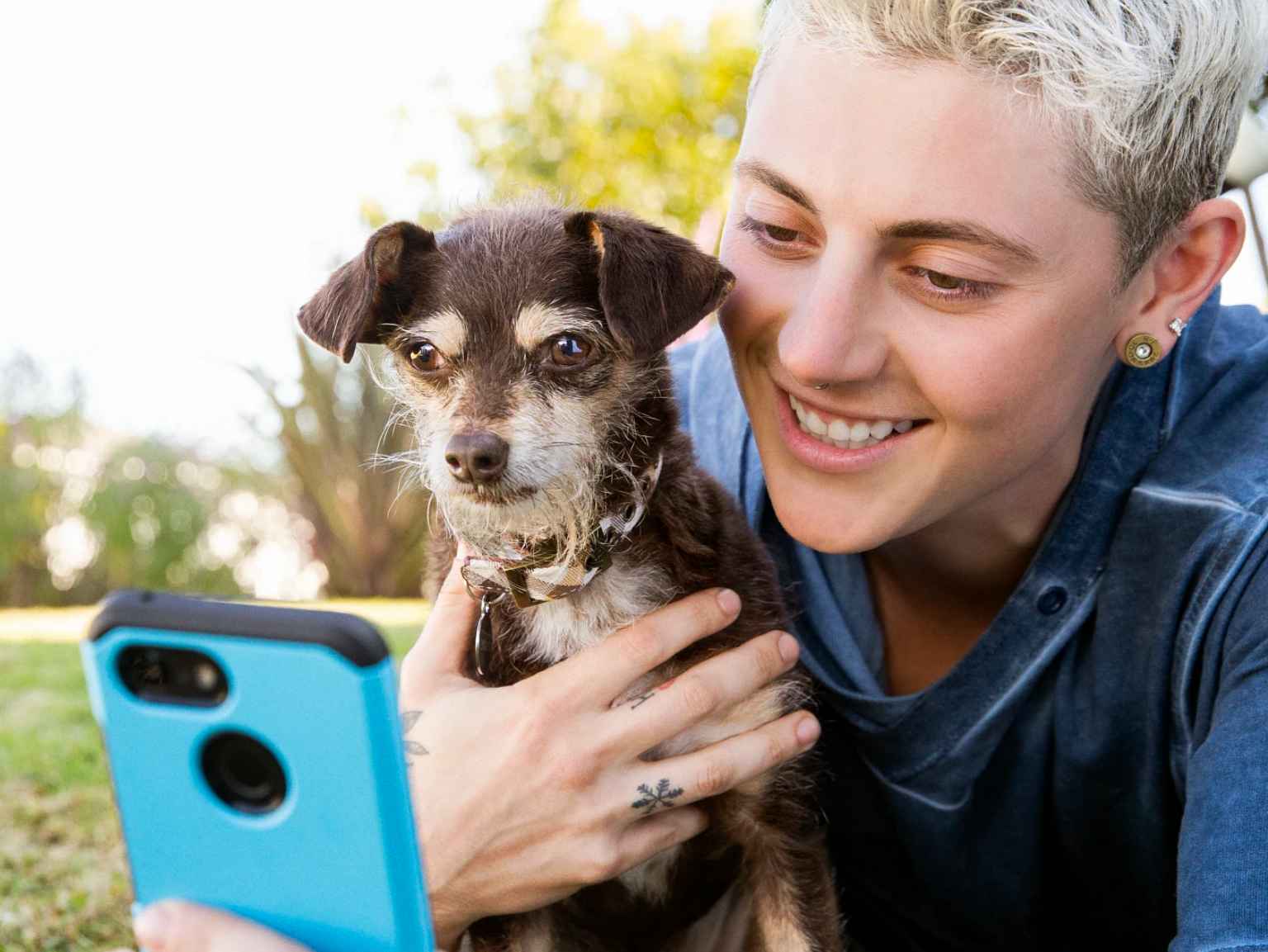 An owner and their puppy using a smart phone.