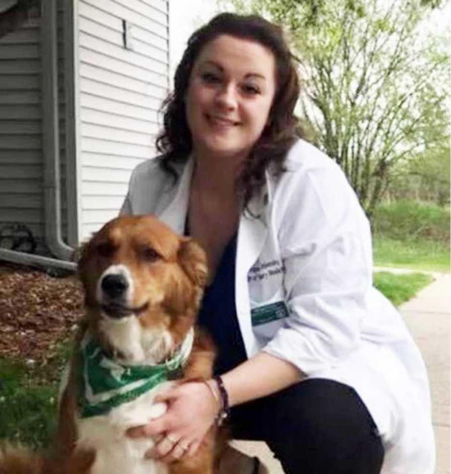 A female Banfield veterinarian holding a dog