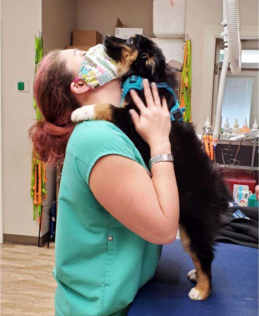 A female veterinarian hugging a dog at the Banfield Pet Hospital, Yadkin Park, NC